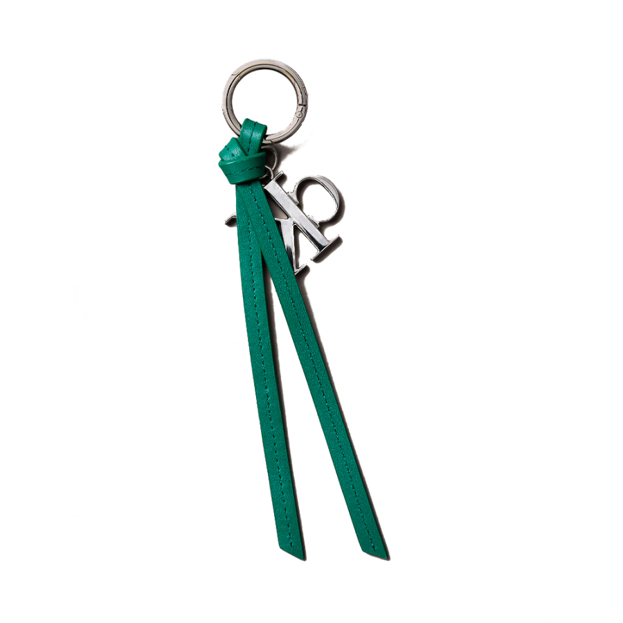 porte-cles-de-sac-a-main-avec-pompon-et-logo-distinctif-en-cuir